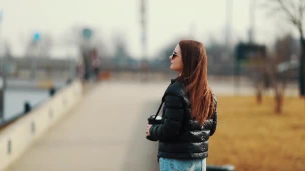 少女歩く通りホールド彼女のカメラと都市景観の写真を撮る — ストック動画