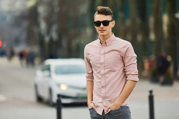 Young boy walking on the city street wear glasses and smile to t