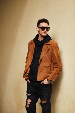 Model görünümlü bir adam duvara yakın dur ve onun gözlük savaşa tutun