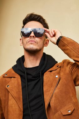 Model görünümlü bir adam duvara yakın dur ve onun gözlük savaşa tutun