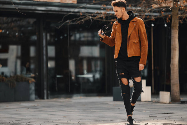 Model looking man stand on the city street with cars background,