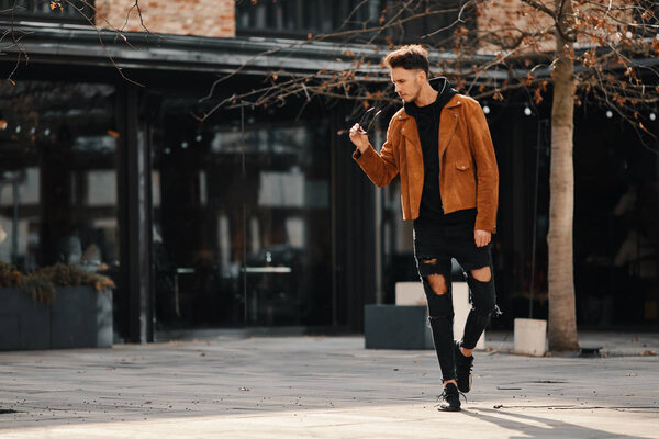 Model looking man stand on the city street with cars background,