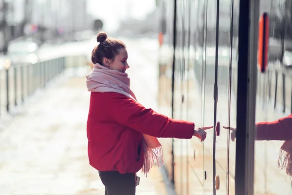Νεαρό κορίτσι στέκονται κοντά το τραμ και σπρώξτε το κουμπί, ηλιοφάνεια — Φωτογραφία Αρχείου
