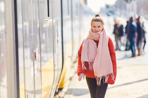 Chica joven de pie cerca del tranvía y pulse el botón, sol — Foto de Stock