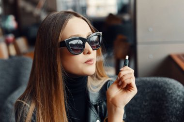 Kız sit caffee yerde ve duman elektronik sigara aşınma gla