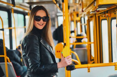 Kız tramvay içinde tutun, bir yandan tüp ve gülümseme t
