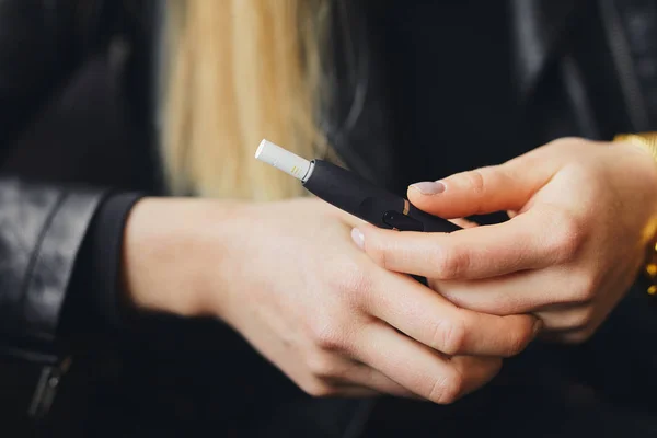 Закрыть электронную сигарету футляром и размыть девушку — стоковое фото