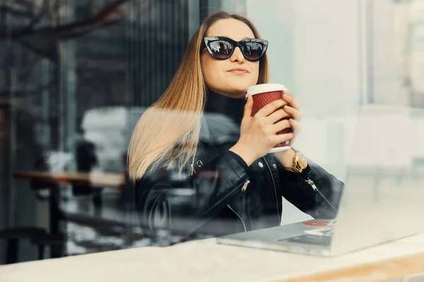 Giovane ragazza sedersi in un posto di caffè di fronte alla finestra guardare lui — Foto Stock