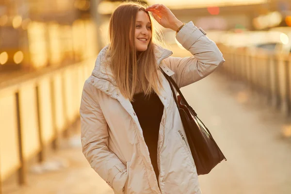 Jeune fille debout sur la place de la rue, regarder la caméra et sourire — Photo