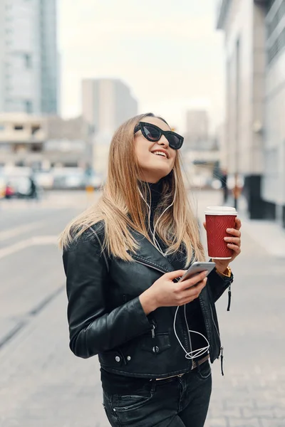 Jolie fille debout dans la rue écouter de la musique de ses écouteurs — Photo