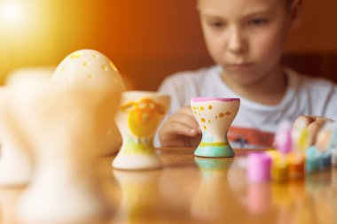 Küçük çocuk yumurta bulanıklık arka plan ve polis tablo çizmek