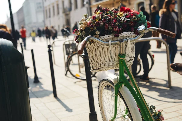 Retro bike with bouquet of flowers stand on the street — Stock Photo, Image