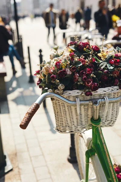 Ретро велосипед с букетом цветов стоять на улице — стоковое фото