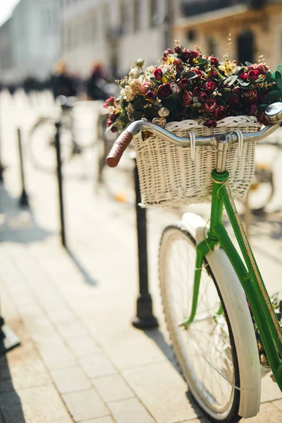 Ретро велосипед с букетом цветов стоять на улице — стоковое фото