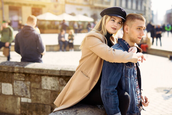 Lovely couple stand on city landscape and hug each other with su