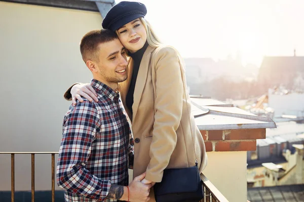 Preciosa pareja de pie en el paisaje de la ciudad y abrazarse mutuamente —  Fotos de Stock