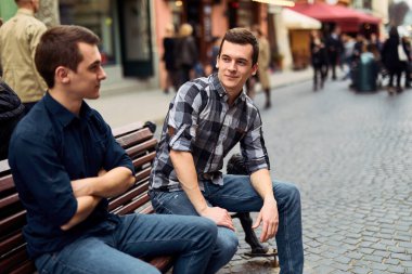 İki adam bankta oturup konuşmak sokaklarda 