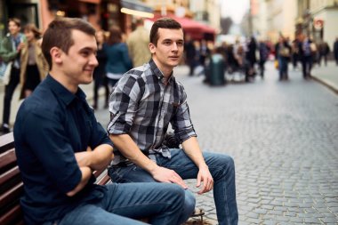 İki adam bankta oturup konuşmak sokaklarda 