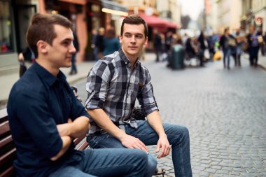 İki adam bankta oturup konuşmak sokaklarda 