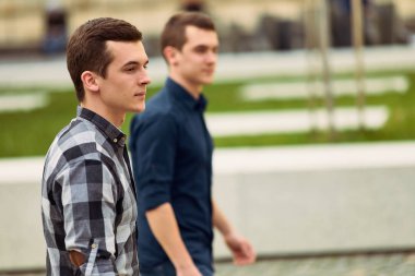 Sokak ve ileriye bakmak üzerinde yürüyen iki adam