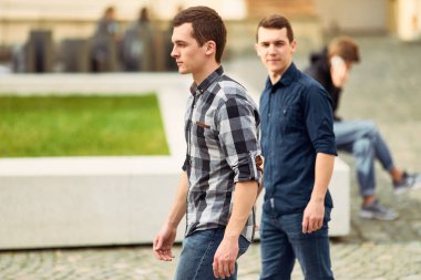 Sokak ve ileriye bakmak üzerinde yürüyen iki adam