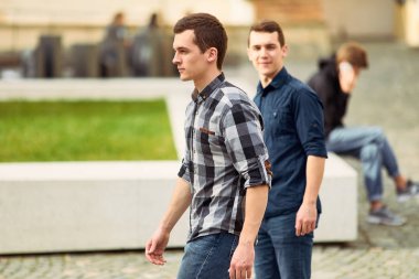 Sokak ve ileriye bakmak üzerinde yürüyen iki adam