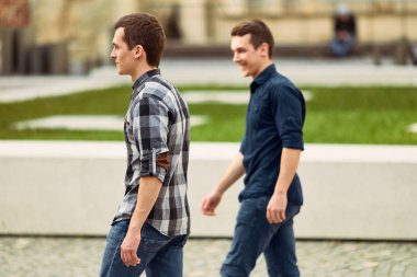 Sokak ve ileriye bakmak üzerinde yürüyen iki adam