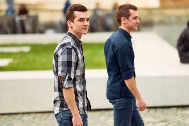 Sokak ve ileriye bakmak üzerinde yürüyen iki adam