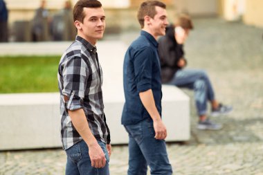 Sokak ve ileriye bakmak üzerinde yürüyen iki adam