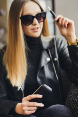 Kız sit caffee yerde ve duman elektronik sigara aşınma gla