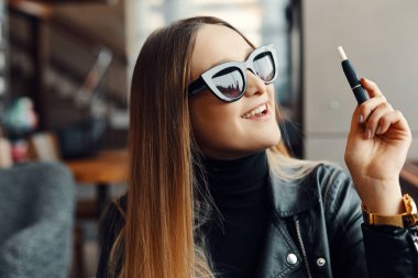 Kız sit caffee yerde ve duman elektronik sigara aşınma gla