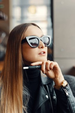 Kız sit caffee yerde ve duman elektronik sigara aşınma gla