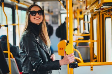 Kız tramvay içinde tutun, bir yandan tüp ve gülümseme t