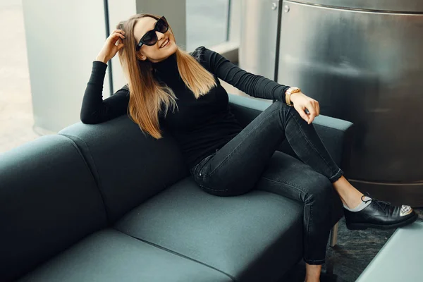 Jeune jolie fille assise sur le canapé porter des lunettes et sourire à venir — Photo