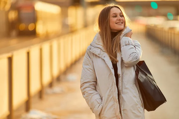 Ung flicka stå på gatan förlägga, titta på kameran och leende — Stockfoto