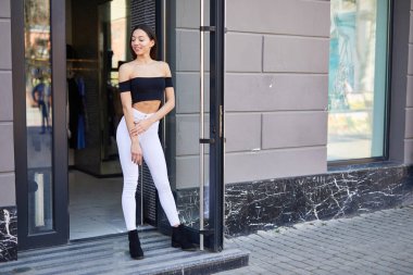 Güzel sportif kız duvara yakın duran ve kamera için poz,