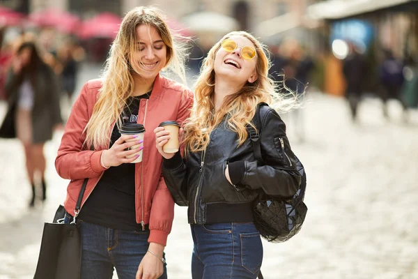 Две девушки идут по городской улице и разговаривают друг с другом — стоковое фото