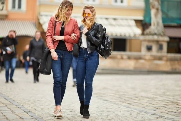 Duas meninas andando na rua da cidade e conversar umas com as outras — Fotografia de Stock