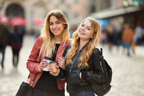 两个女孩走在城市街道上互相交谈 — 图库照片