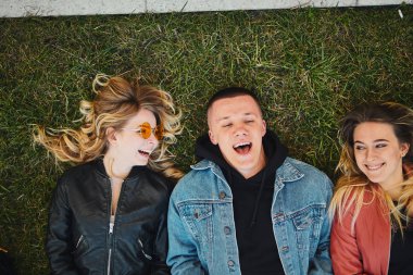 Yeşil çim konuşuyor ve gülümseme camer için iki kızla çocuk