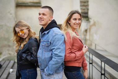 İki kız ve erkek gülümseme ve kamera için poz