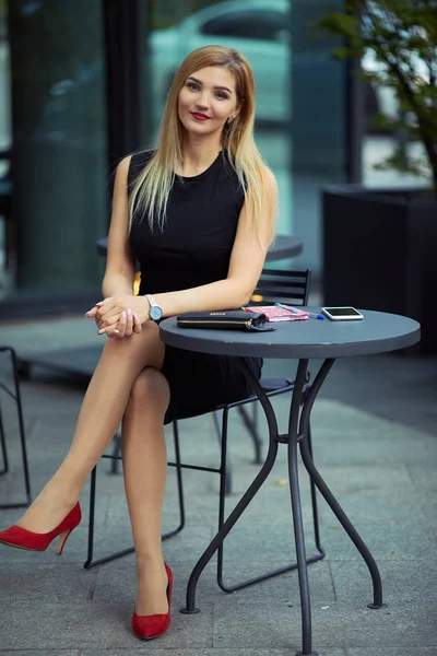 Menina bonita sentada na mesa e fazer o seu trabalho, falar no pho — Fotografia de Stock