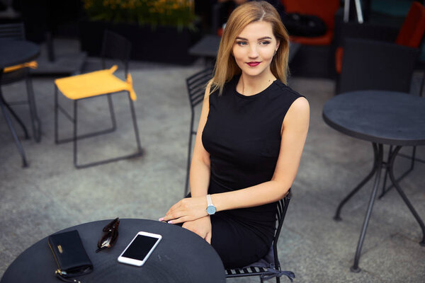 Beautiful girl sitting on the table and do her work, talk at pho