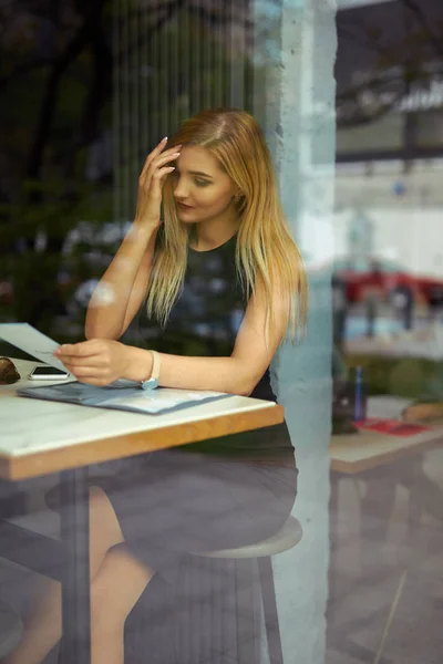 Menina bonita sentada na mesa e fazer o seu trabalho, falar no pho — Fotografia de Stock