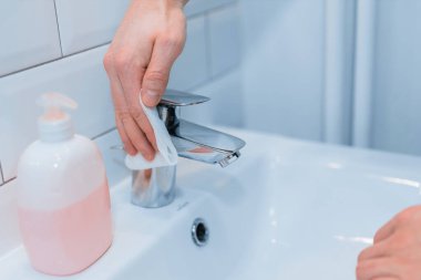 Koronavirüsü temizliyorum. Temiz ve dezenfekte edici ev yüzeyleri: masalar, ışık düğmeleri, uzaktan kumandalar, saplar, masalar, tuvaletler, lavabolar.