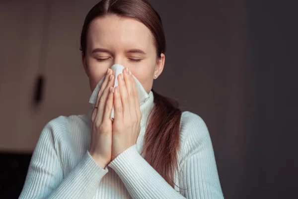Öksürürken burnu ve ağzı kaplayan dokuda öksürük. Avrupalı kadın evde grip olmuş..