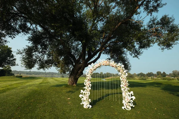Güzel düğün kemer çiçek ağaçları ile arka plan yeşil sahada