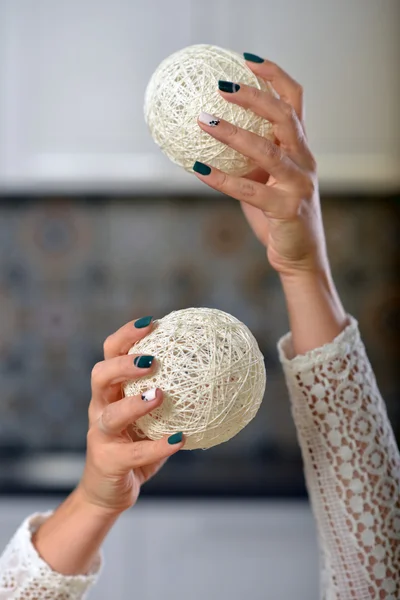 Mãos femininas com manicure segurando as mãos bolas de malha . — Fotografia de Stock