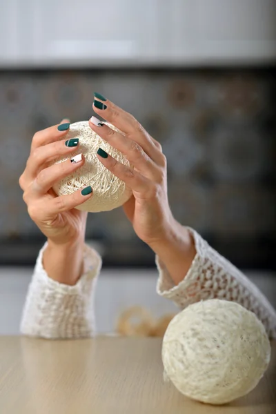 Mãos femininas com manicure segurando as mãos bolas de malha . — Fotografia de Stock