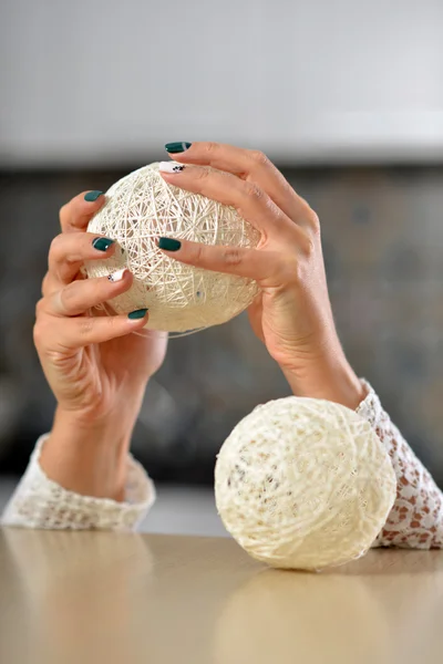 Mãos femininas com manicure segurando as mãos bolas de malha . — Fotografia de Stock